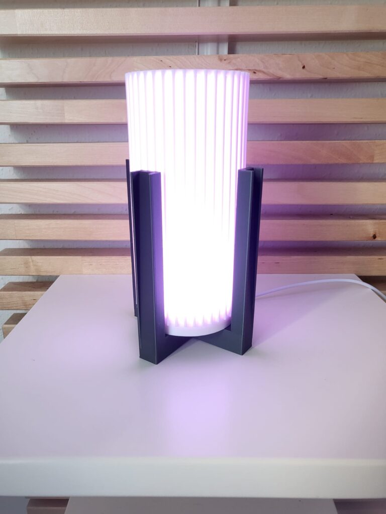 Lámpara de mesa moderna Lira con base negra y luz RGB regulable, ideal para decoración de salón y mesita de noche.