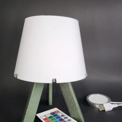 Lámpara de mesa Triada con base verde y pantalla blanca, diseño minimalista para decoración de hogar.